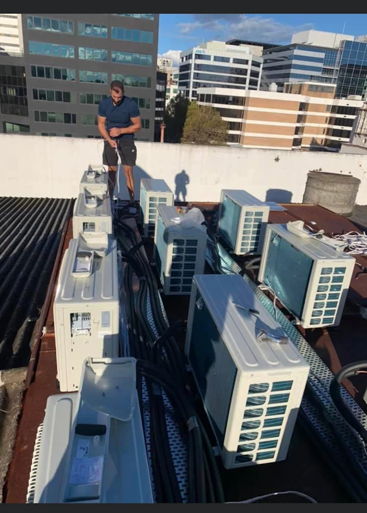 JAE technician commissioning rooftop air conditioning units in Sydney